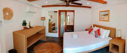 a bedroom with a bed and a desk in a room at Tropical Temple Siargao Resort in General Luna