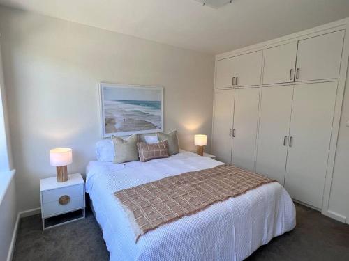 una camera da letto con un grande letto con due lampade sopra di Modern Beach Oasis in Elwood Village a Melbourne