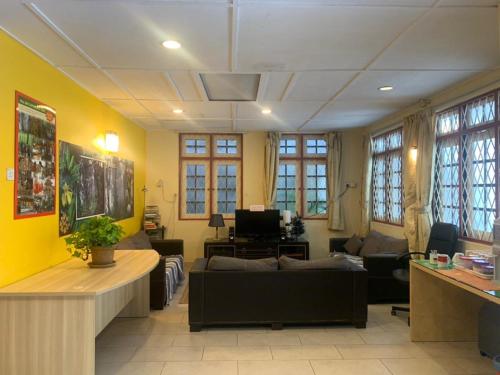 salon z żółtymi ścianami i kanapą w obiekcie Vintage Guesthouse w mieście Tanah Rata