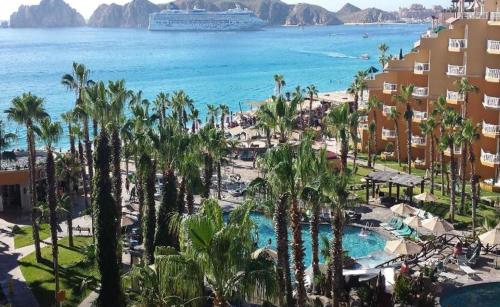 a view of a beach with palm trees and a cruise ship at Suites at Villa Del Palmar Cabo San Lucas Beach Resort and Spa in Cabo San Lucas