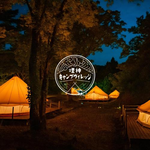 eine Gruppe von Zelten mit einem Schild in der Nacht in der Unterkunft 煙神キャンプヴィレッジ in Toyooka