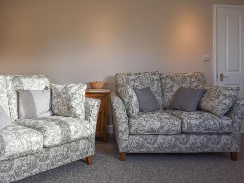 two chairs and a couch in a living room at Blacksmiths Cottage in Upwey