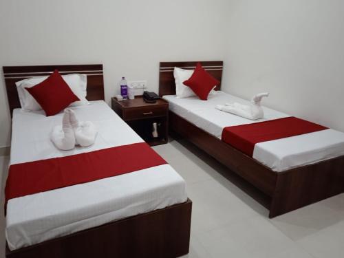 2 Betten in einem Hotelzimmer mit Schwänen darauf in der Unterkunft HOTEL HAREN GRAND in Guwahati