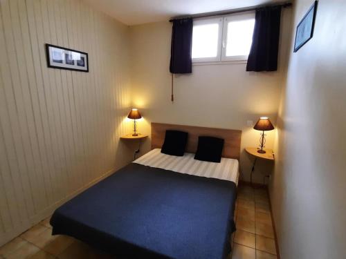 1 dormitorio pequeño con 1 cama y 2 lámparas en Appartement La Roche-Posay, 2 pièces, 4 personnes - FR-1-541-78, en La Roche-Posay