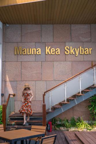 a woman in a dress walking down stairs in front of a building at Diamond Sea Hotel in Da Nang