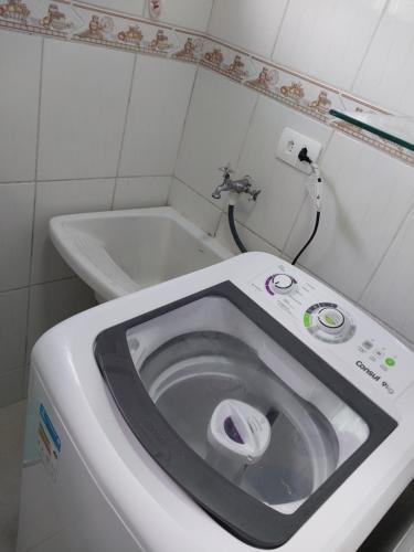 a white toilet in a bathroom with a sink at Apartamento Conforto in Curitiba