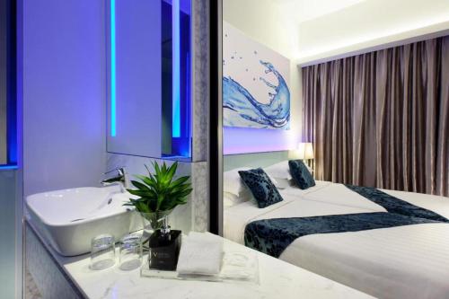 a hotel room with two beds and a sink at Vivatel Kuala Lumpur in Kuala Lumpur