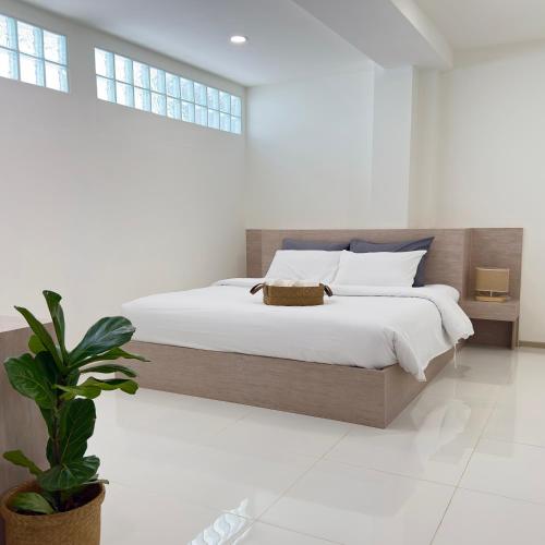 a bedroom with a large bed and a potted plant at Darin Chiangmai Hotel and Residence in Chiang Mai