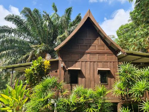 uma casa de madeira com telhado de palha em Thai Heritage Koh Mak em Ko Mak