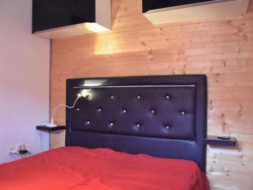 - une chambre avec un lit rouge et une tête de lit noire dans l'établissement Pavillon Climatisé avec Piscine Proche Mer - 5 Couchages, Terrasse Intime - Gruissan - FR-1-229-811, à Gruissan