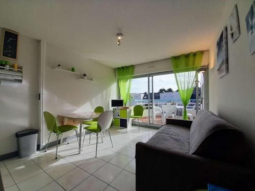 un salon avec un canapé et une table avec des chaises dans l'établissement Appartement cosy à Carnac, 2 pièces, proche plages et thalasso, balcon sud, parking, animal accepté - FR-1-477-221, à Carnac