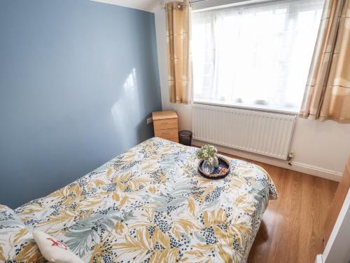 1 dormitorio con 1 cama con colcha y una planta en Field View en Grimsby