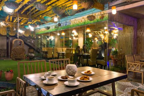 a wooden table with plates of food on it in a restaurant at EllBee Ganga View in Rishīkesh