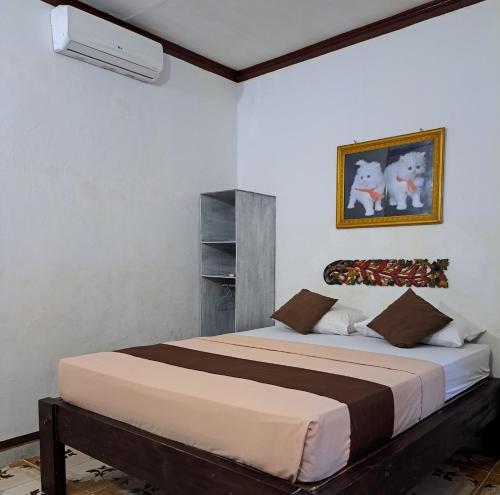 1 dormitorio con 1 cama grande en una habitación en Cozy Alfia Inn, en Gili Trawangan