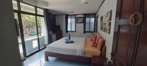 - une chambre avec un lit dans une pièce dotée de fenêtres dans l'établissement Kohkaew Village 2@Kohsamet, à Ko Samet