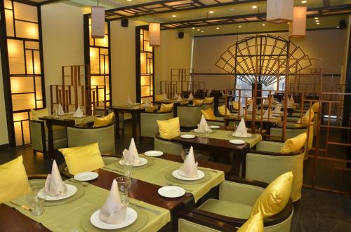 un restaurante con mesas y sillas con sombreros en The HQ, en Vasco Da Gama
