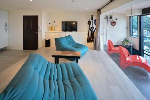 a living room with a blue couch and red chairs at Windsor's Sunlight Han-Guan in Jiufen