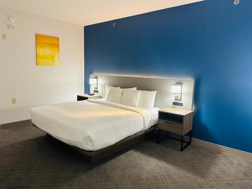 a bedroom with a large bed with a blue wall at Comfort Inn & Suites Wylie in Wylie