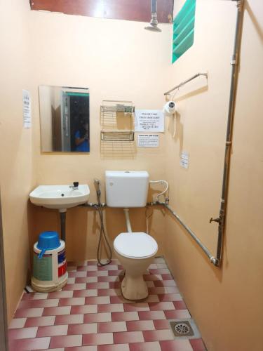 a bathroom with a toilet and a sink at Cheers Garden Chalet in Kampung Tekek