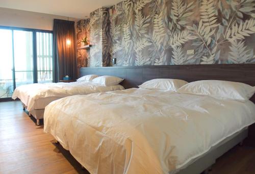 duas camas num quarto de hotel com lençóis brancos em Day and Day Hotel No1 em Tianwei