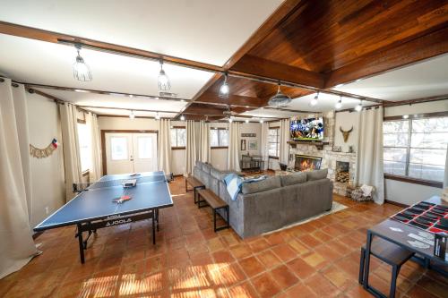 sala de estar con mesa de ping pong y sofá en Gorgeous rustic home near River Walk and Sea World en San Antonio