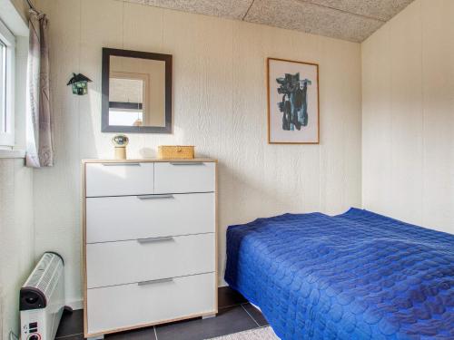a bedroom with a blue bed and a dresser at 6 person holiday home in Pandrup-By Traum in Pandrup