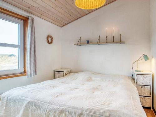 a white bedroom with a bed and a window at 6 person holiday home in Pandrup-By Traum in Pandrup