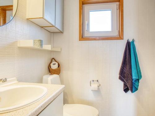 a bathroom with a sink and a toilet and a window at 6 person holiday home in Pandrup-By Traum in Pandrup