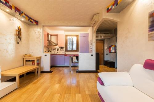 a living room with a white couch and a kitchen at Andy's cozy little place in Baggio