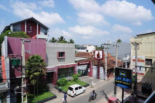 a city street with a white van parked in front of a building at UK Inn Guest House in Jaffna
