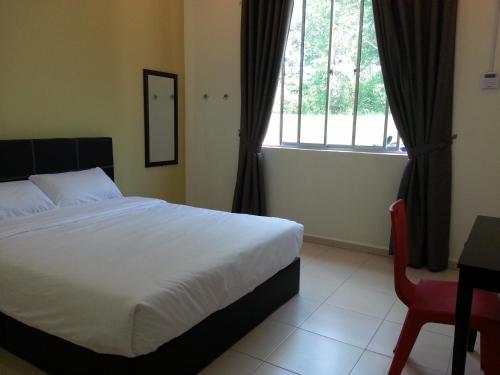 a bedroom with a bed and a desk and a window at Alor Villa in Malacca