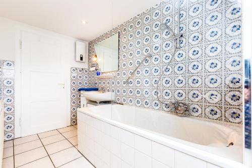 a bathroom with a tub and a sink and a mirror at Apartments Bensberg in Bergisch Gladbach