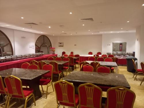 Hayah Diamond Hotel في المدينة المنورة: غرفة بها طاولات وكراسي حمراء