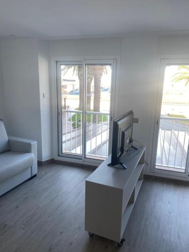 a living room with a tv and a couch at Loft amb vistes al mar 150 mts to Nautical Club Christmas R in Palamós