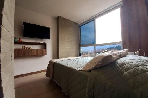 1 dormitorio con 1 cama y TV de pantalla plana en 701 Loft amazing view, en Medellín