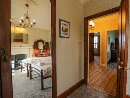 1 dormitorio con cama y pasillo con espejo en Groffa Crag Farmhouse en Lowick Green