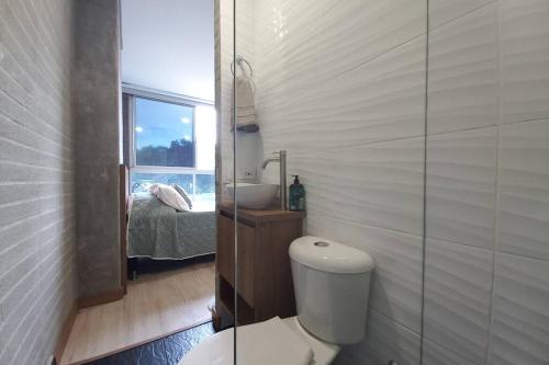ein Bad mit einem WC, einem Waschbecken und einem Fenster in der Unterkunft 702 Belen, Loft amazing view in Medellín