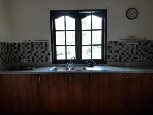 a kitchen with a sink and a window at Harmony House Stay in Padangbai