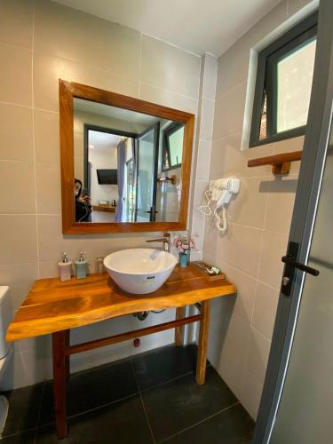 a bathroom with a sink and a mirror at The Legend Coco Beach in Mui Ne