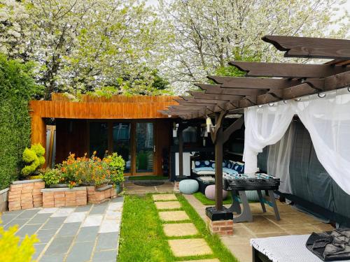 a backyard with a patio with a wooden pergola at Tropical Style House Near Newcastle City Centre in Newcastle upon Tyne