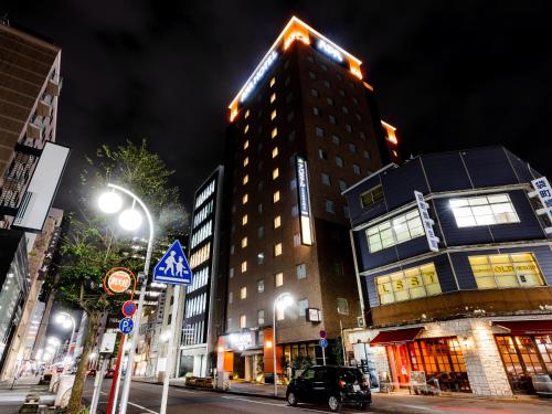 a tall building on a city street at night at APA Hotel Nagoya Fushimi Ekikita in Nagoya