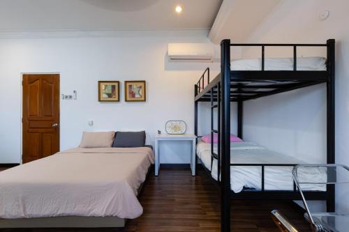 a bedroom with two bunk beds and a desk at Crossover Hub Family Balcony Room in George Town