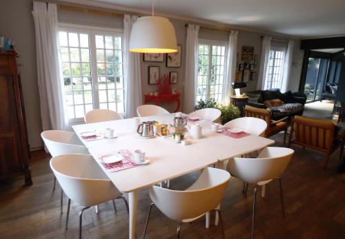 une salle à manger avec une table et des chaises blanches dans l'établissement Bed & Breakfast La Clepsydre, à Fontenay-aux-Roses