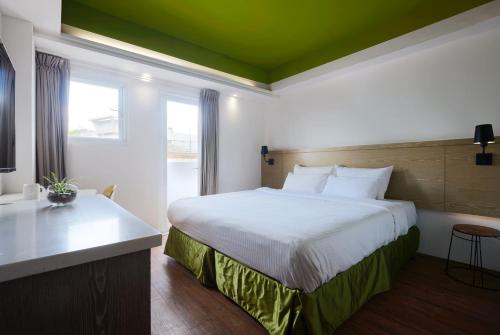 a bedroom with a large white bed and a window at Papersun Hotel in Taipei