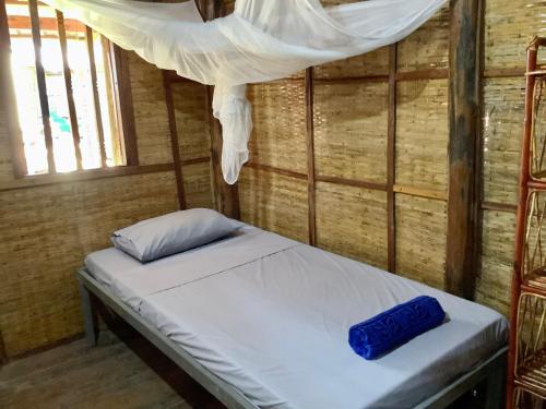 a bed in a room with a canopy at CocoHuts in Koh Rong Sanloem