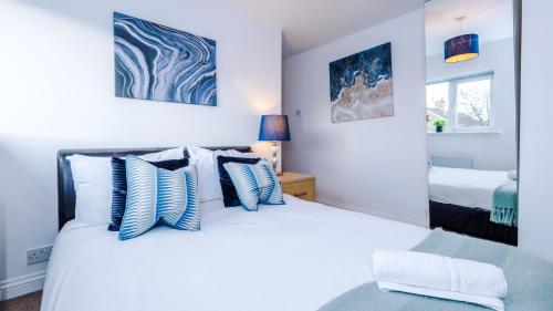 a bedroom with a bed with blue and white pillows at Newhall Road - 4 Bedroom Chester Home - Parking in Wervin