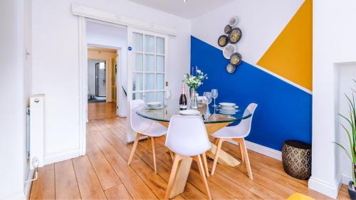 a dining room with a glass table and white chairs at Newhall Road - 4 Bedroom Chester Home - Parking in Wervin