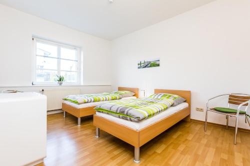 1 dormitorio con 2 camas y ventana en Apartments Bensberg, en Bergisch Gladbach