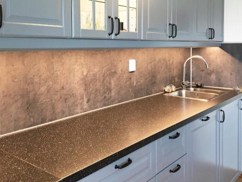 a kitchen with a sink and white cabinets at Five-Bedroom Holiday home in Masfjordnes in Masfjorden