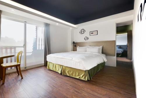 a hotel room with a bed and a balcony at Papersun Hotel in Taipei